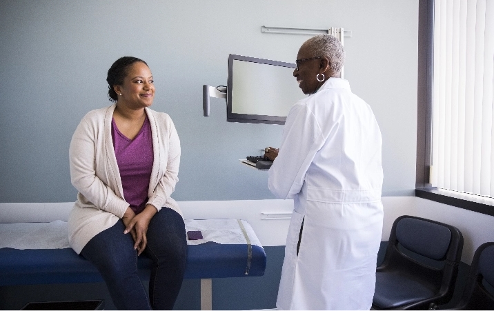 Doctor and patient having a conversation in a doctors office.